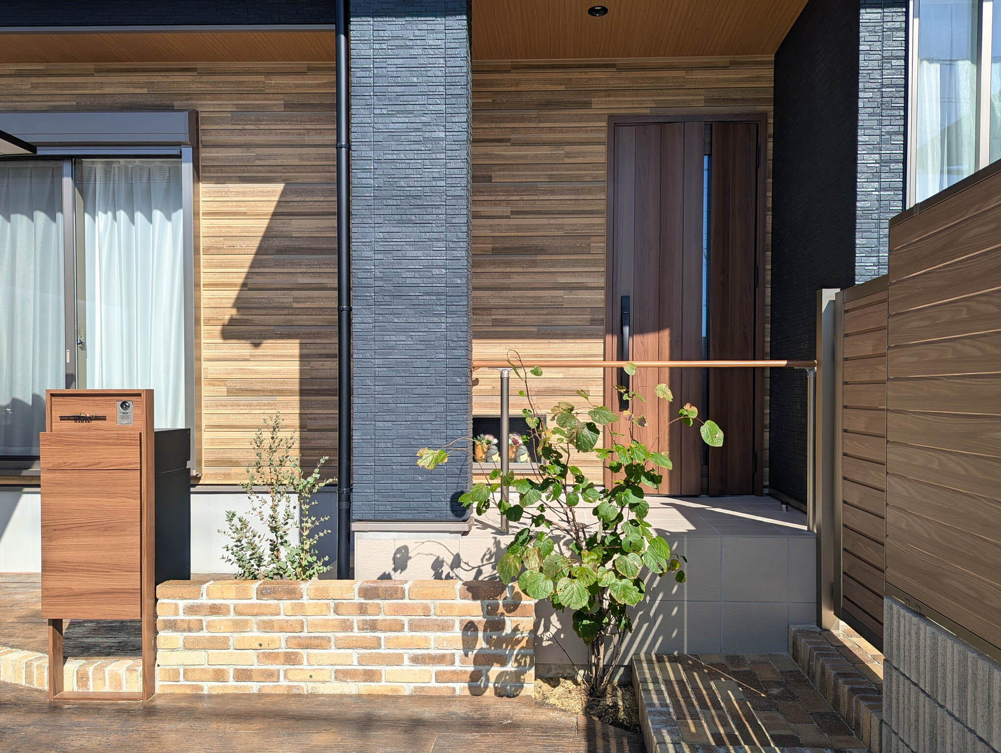 愛知県津島市　扉と色味を合わせた機能門柱にレンガと植栽で彩る玄関周り
